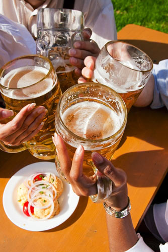 Four people with beer steins making toast